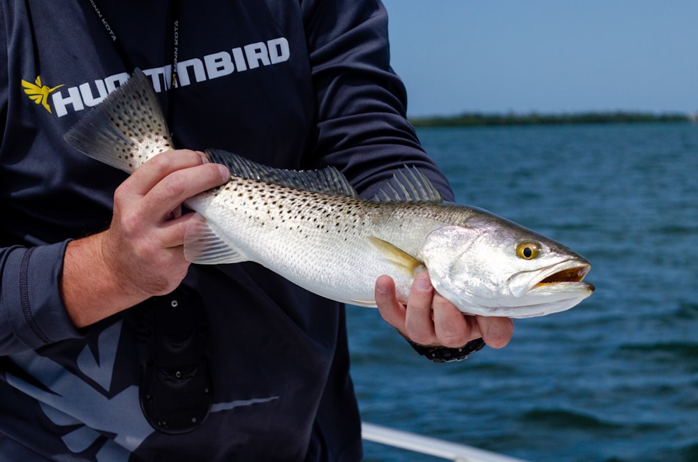 ボートで魚を抱く男