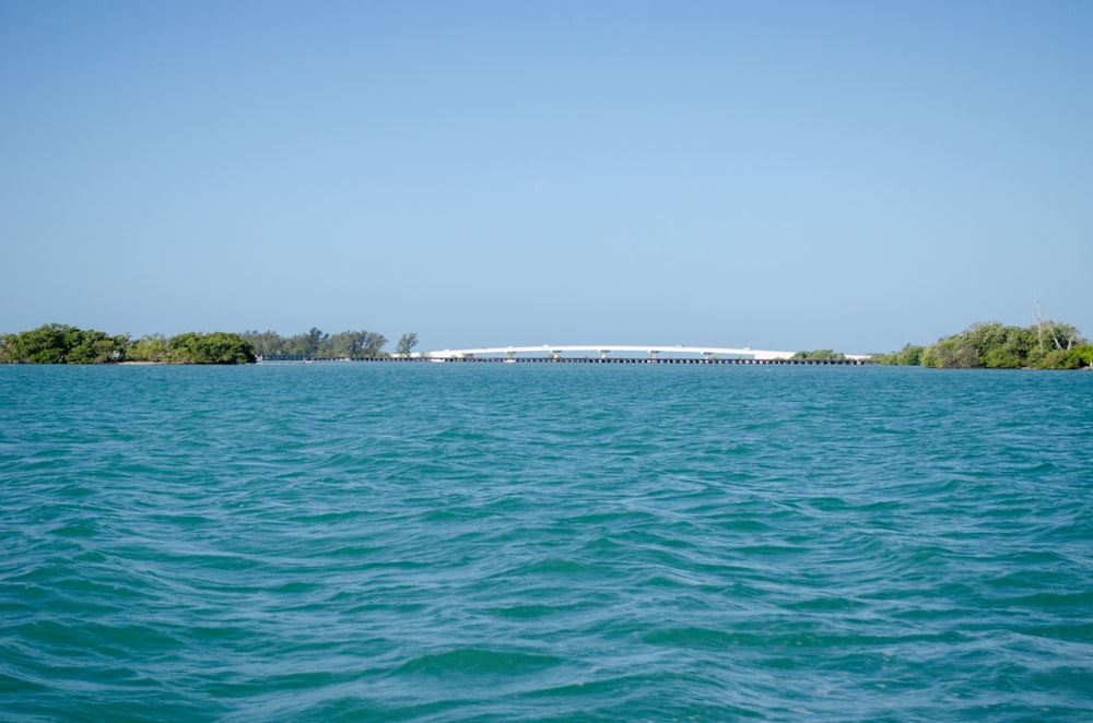 a large body of water with a bridge in the distance