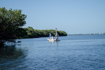 a man standing on a boat in the middle of a lake
