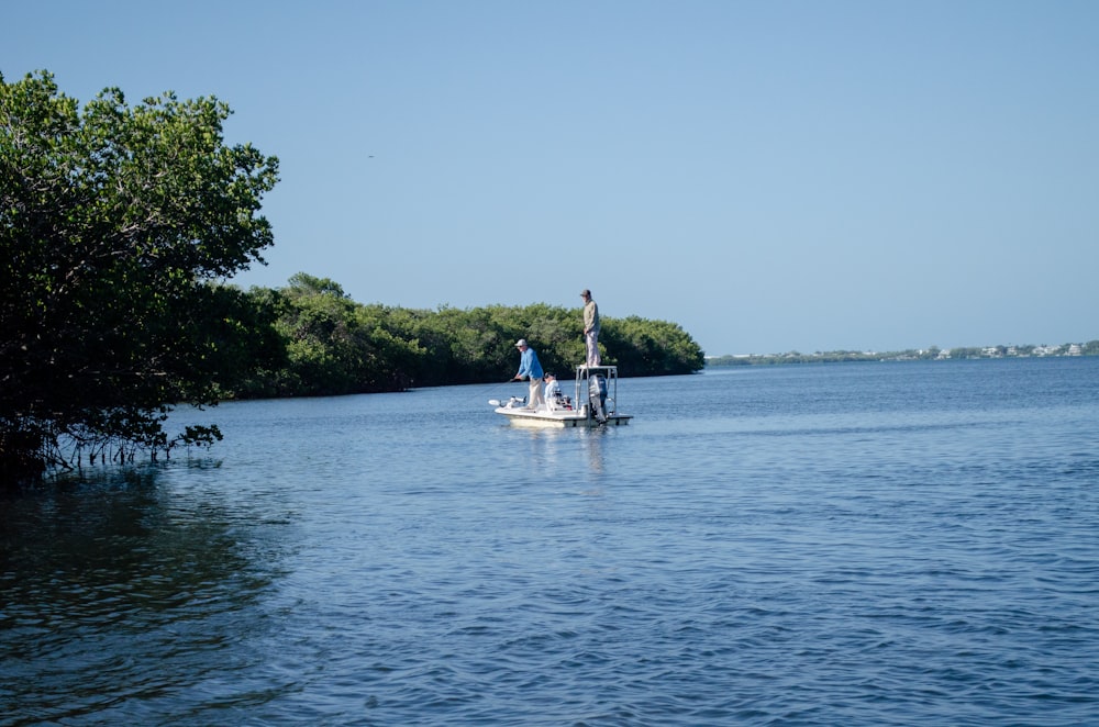 a man standing on a boat in the middle of a lake