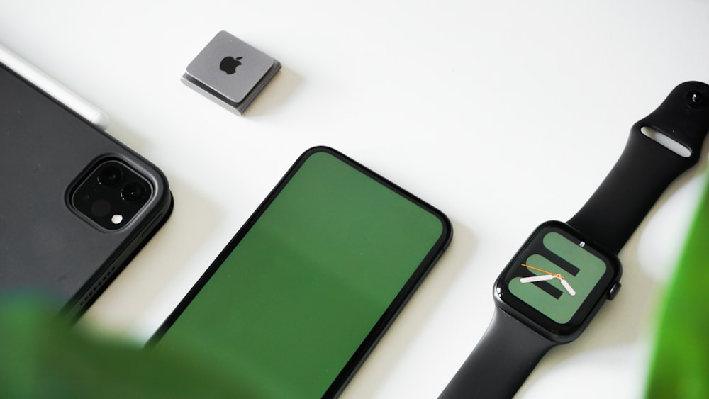 an apple watch, a cell phone, and a green screen