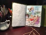 A close-up of a weathered sketchbook page featuring colorful travel-inspired doodles and notes.