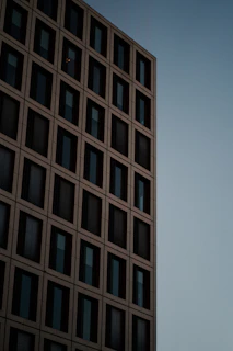 A striking exterior shot of a contemporary building with a grid-inspired facade at dusk