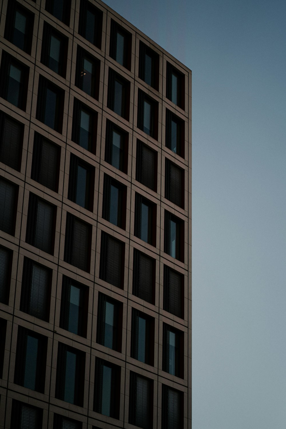 a plane flying in the air near a tall building