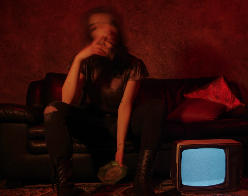 a woman sitting on a couch in front of a tv