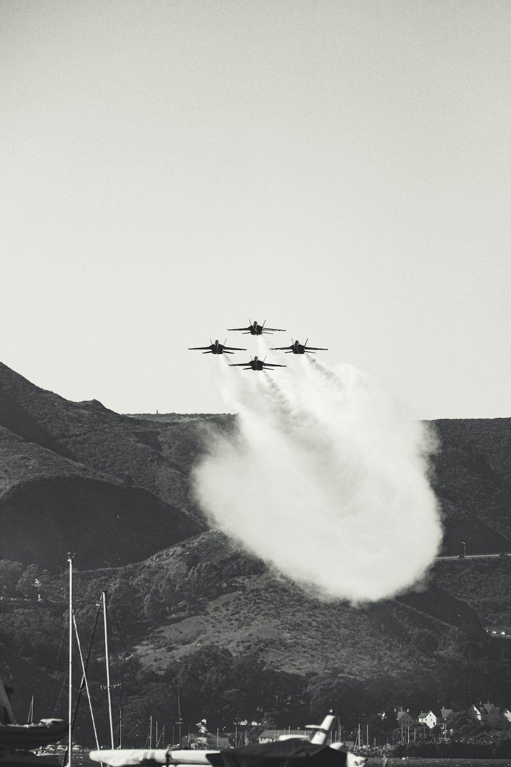 a black and white photo of four airplanes flying in formation