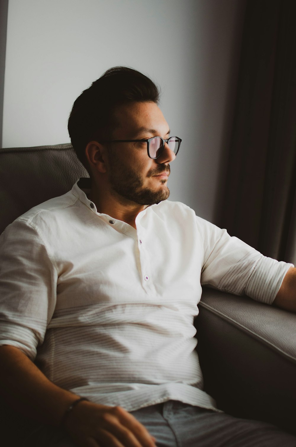 a man sitting in a chair looking out the window