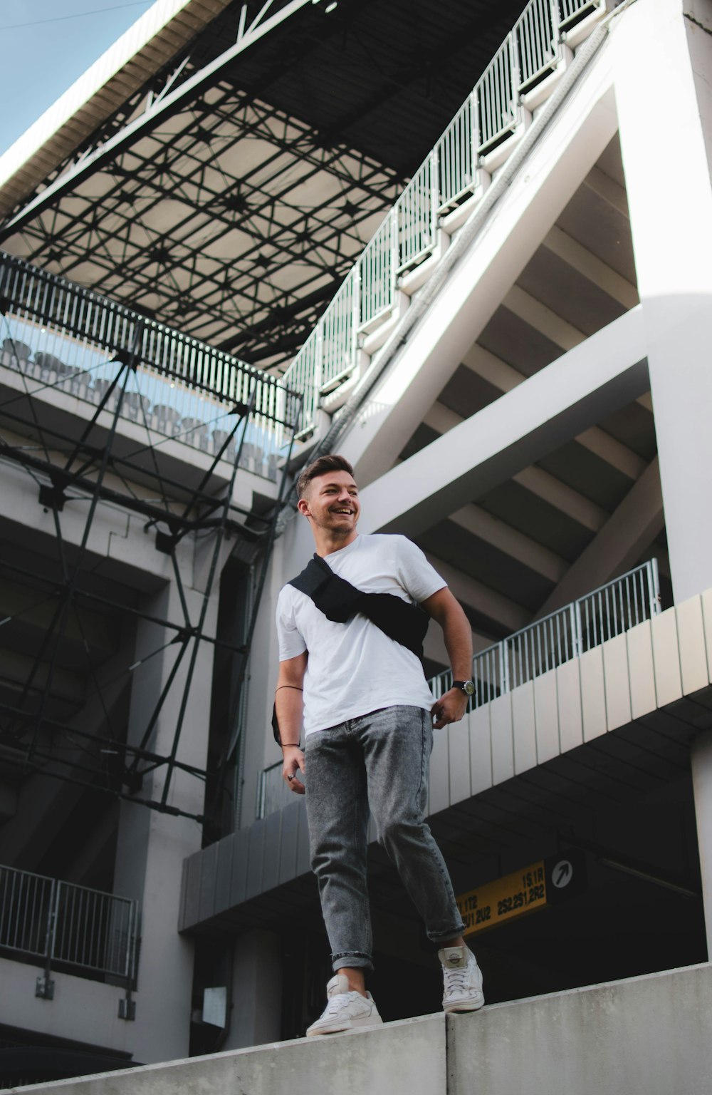 a man standing on a ledge with a tie around his neck