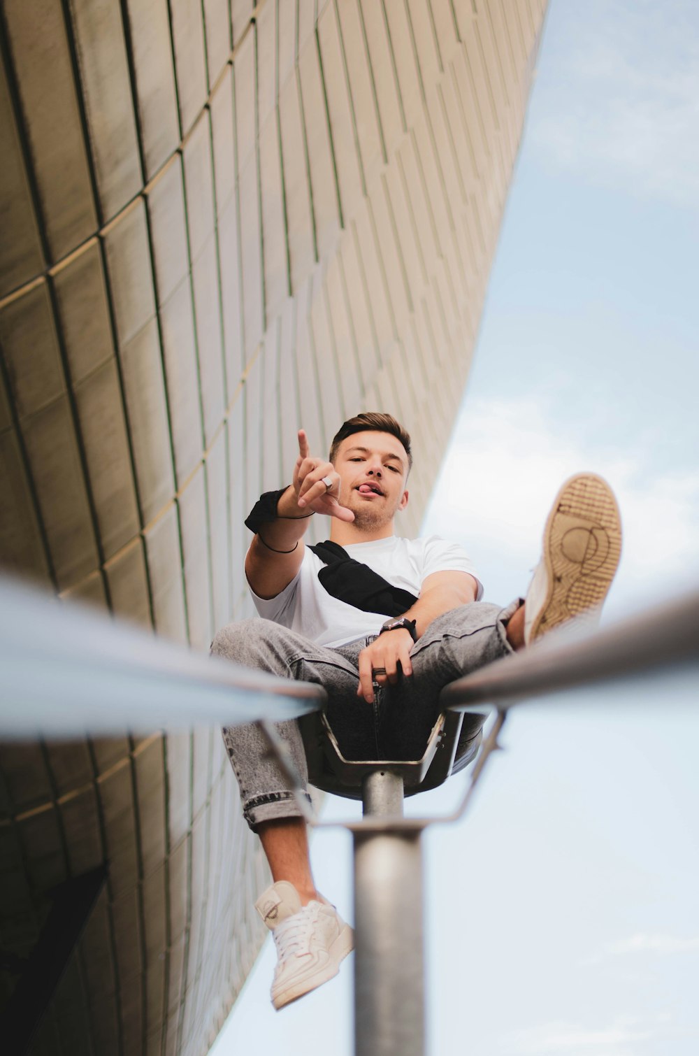 a man sitting on top of a metal pole