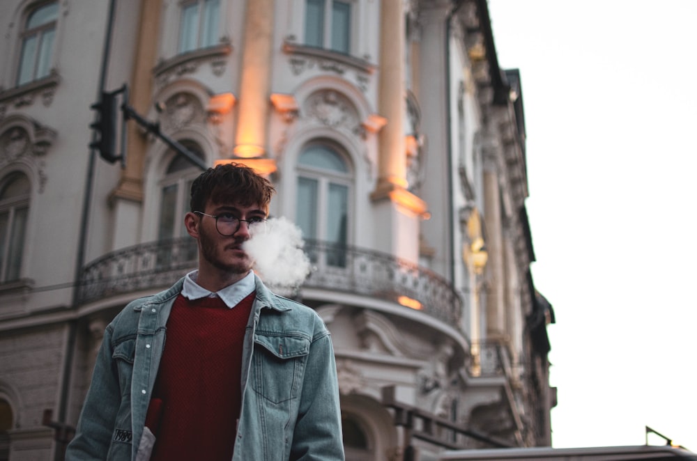 a man smoking a cigarette in front of a building
