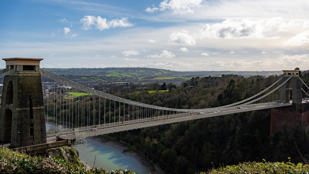 a suspension bridge over a river in a valley