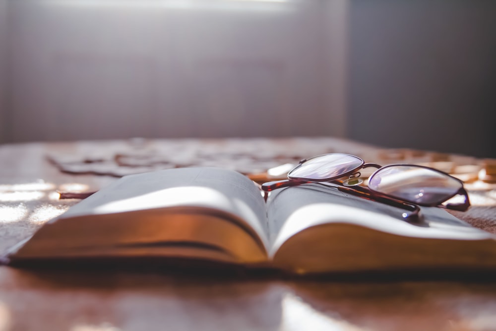 an open book with glasses on top of it