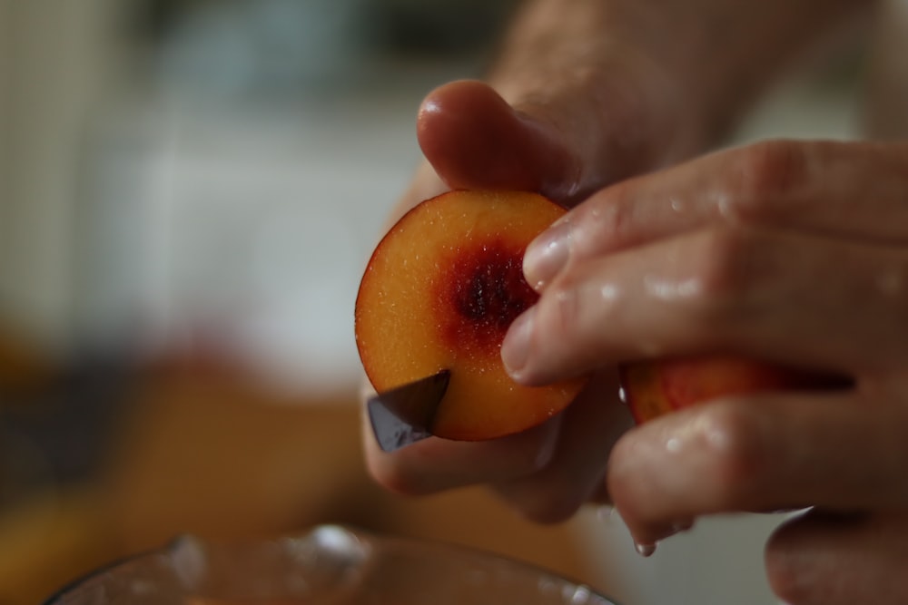 a person holding a piece of fruit in their hand