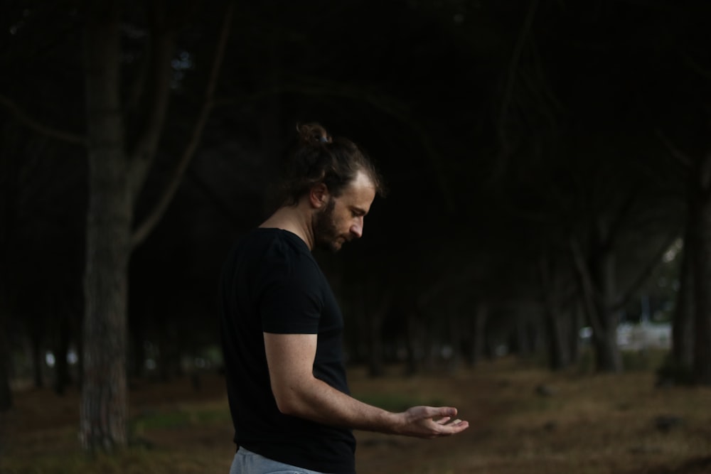 a man standing in a forest holding a frisbee