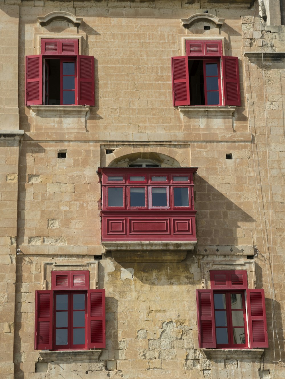 a brick building with red shutters and windows