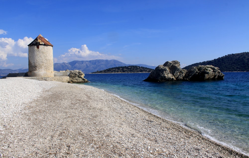 a small tower sitting on top of a beach next to the ocean