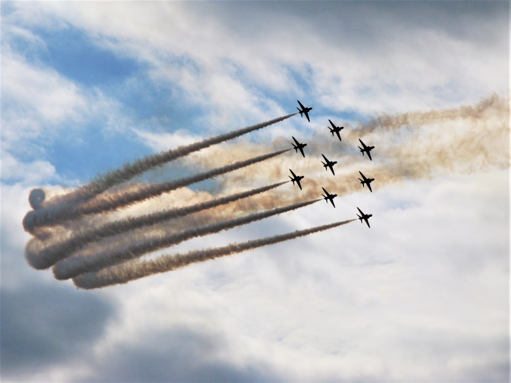Eine Gruppe von Jets fliegt durch einen bewölkten Himmel