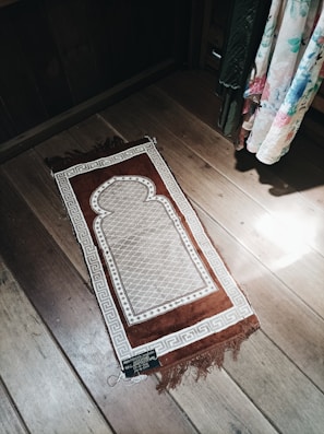 A cozy prayer rug laid out in a sunlit minimalist living room.