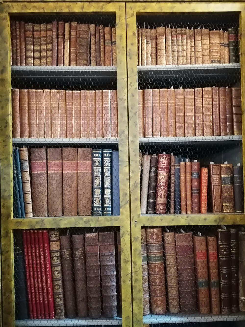 a bookshelf filled with lots of old books