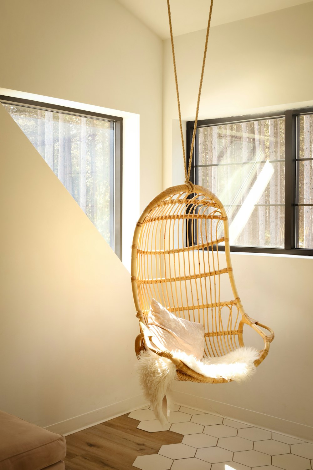 a hanging chair in a room with a window