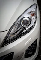 Before and after shot of a headlight restoration on a white SUV.