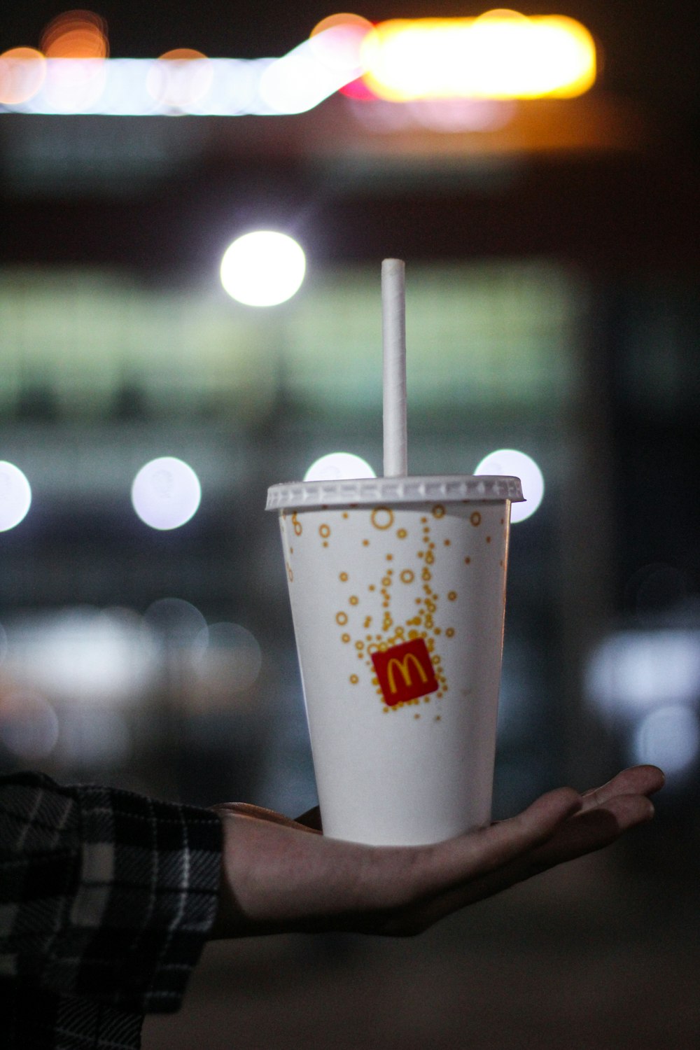 a person holding a cup with a straw in it