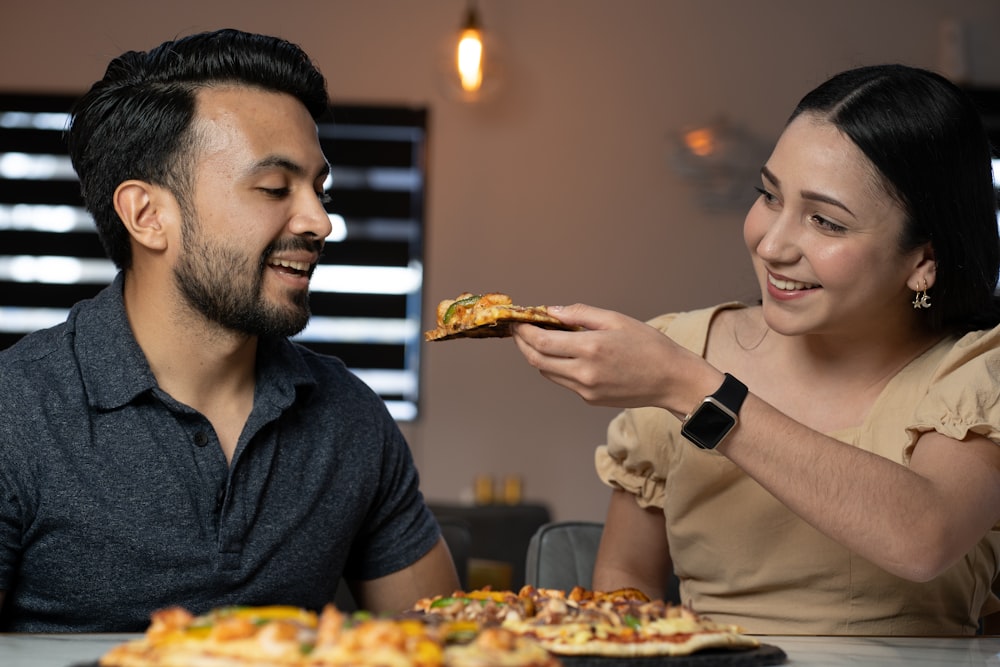 a man and a woman eating pizza together