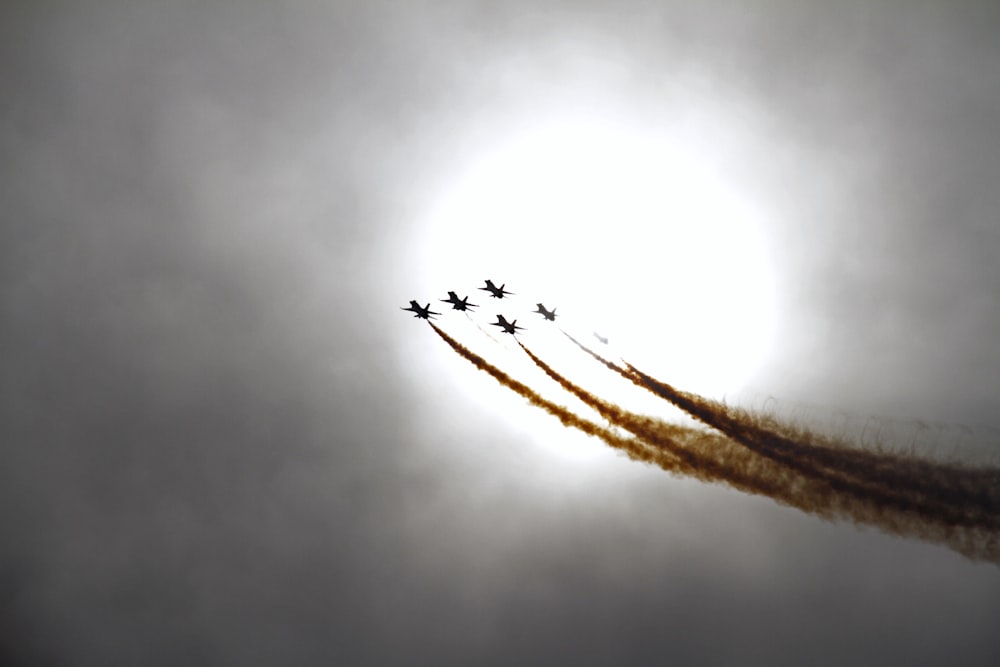 Eine Gruppe von Jets fliegt durch einen bewölkten Himmel