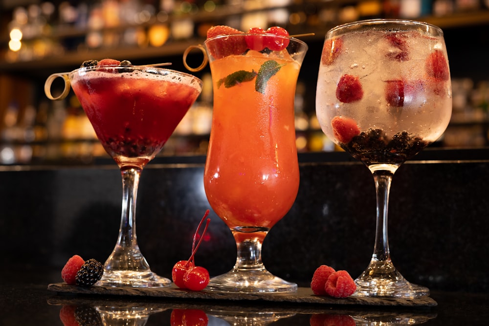 three different types of drinks on a bar