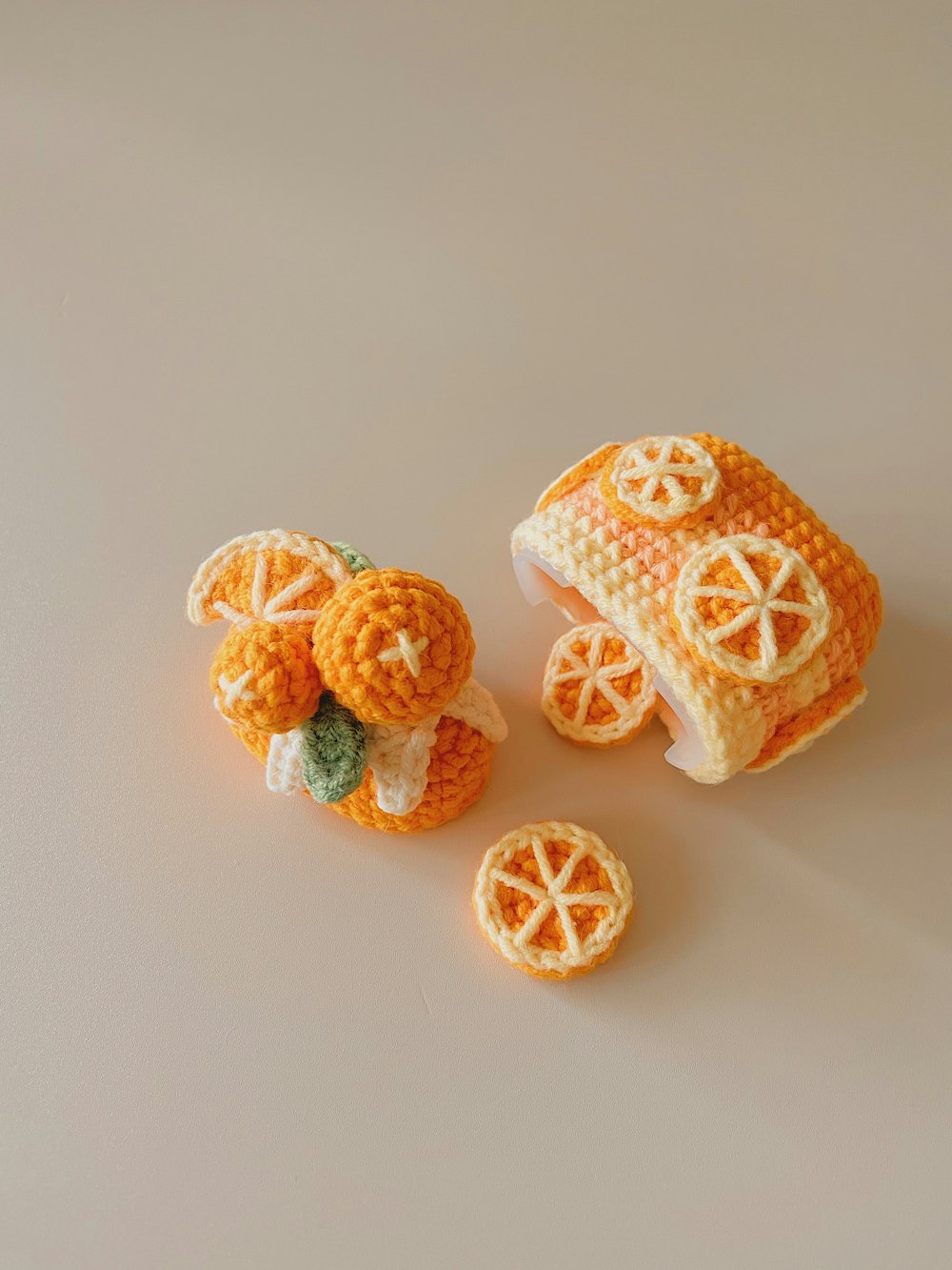 a small crocheted orange with a piece of fruit on top of it