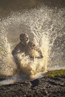 Electric motorcycle riding through puddles, splashing water without any damage