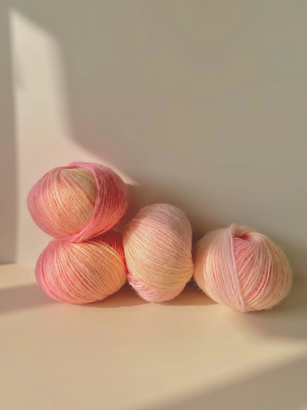 three skeins of pink yarn on a white surface