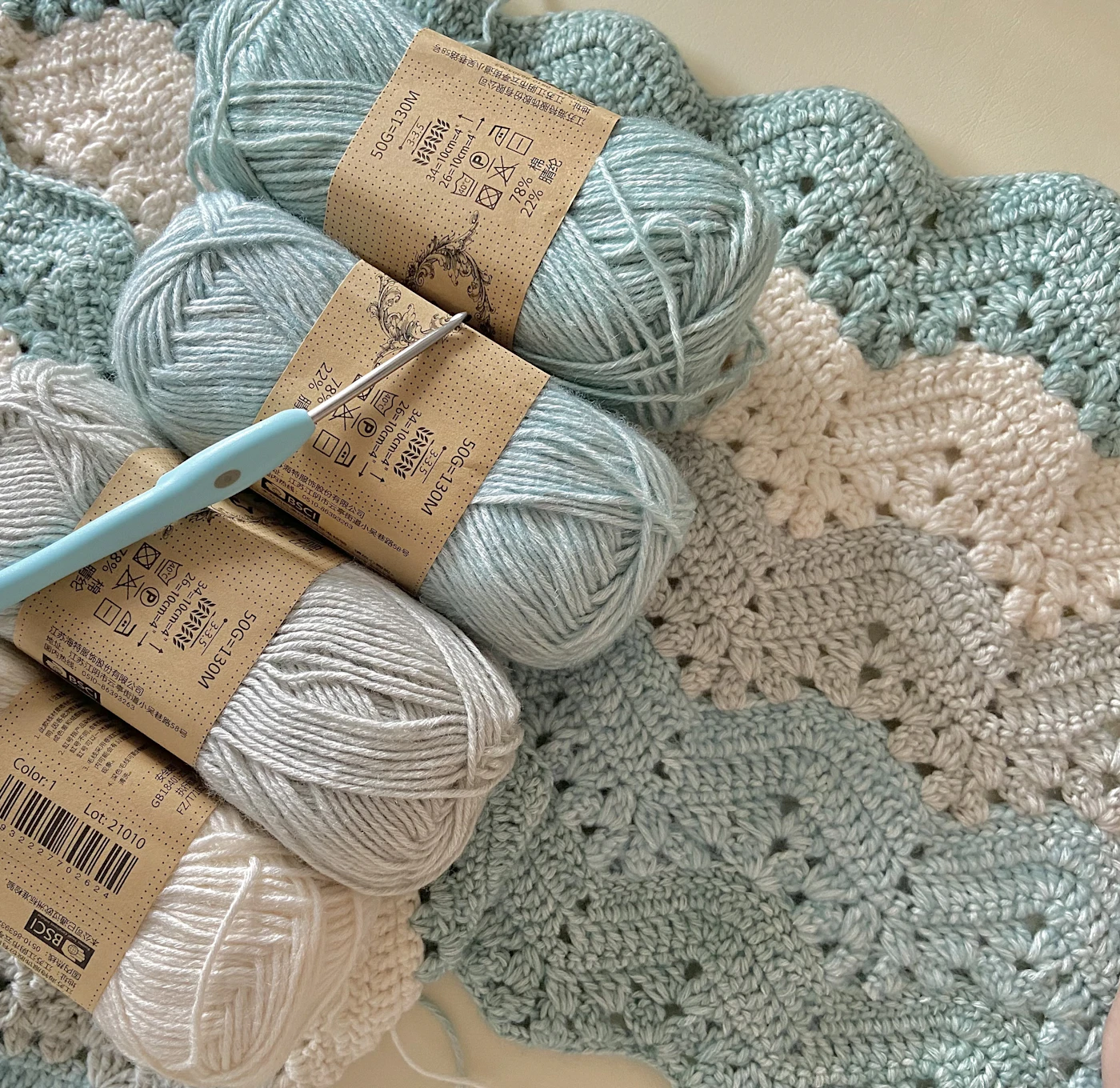 Crochet hook and yarn on handmade crochet work
