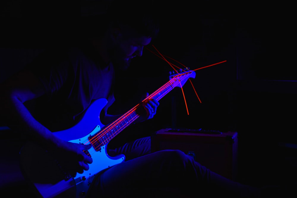 a man playing a guitar in the dark