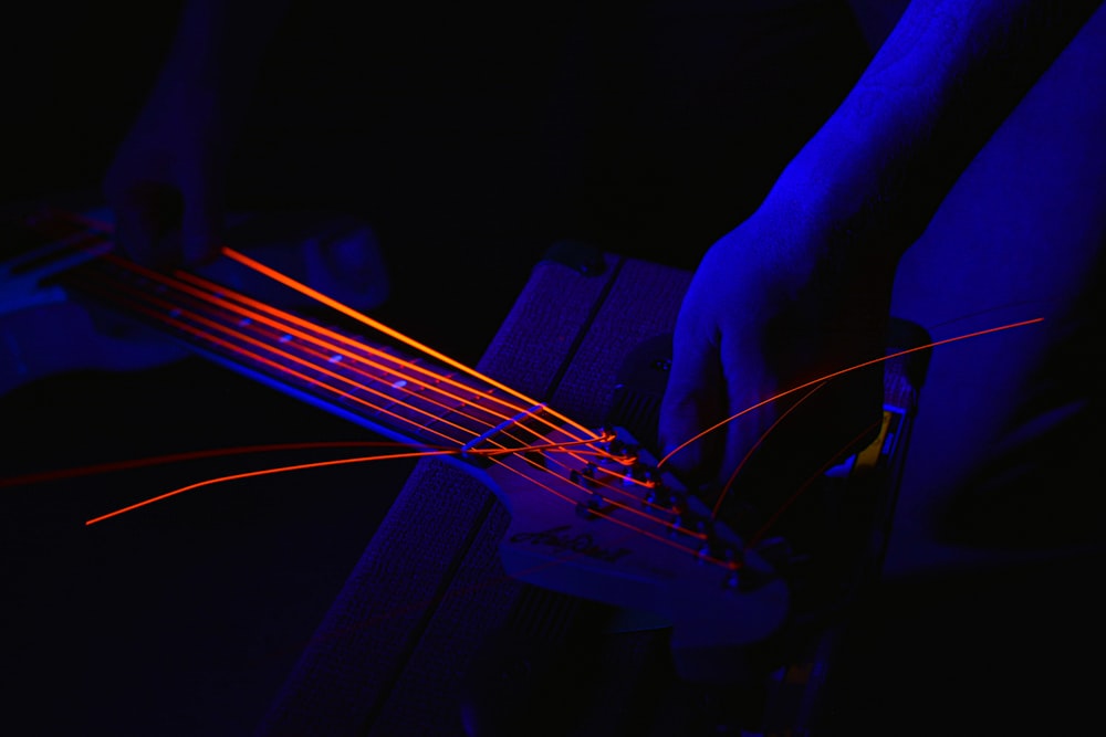 a person playing a guitar in a dark room