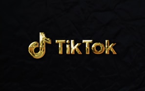 The image features a golden TikTok logo set against a dark, textured background.