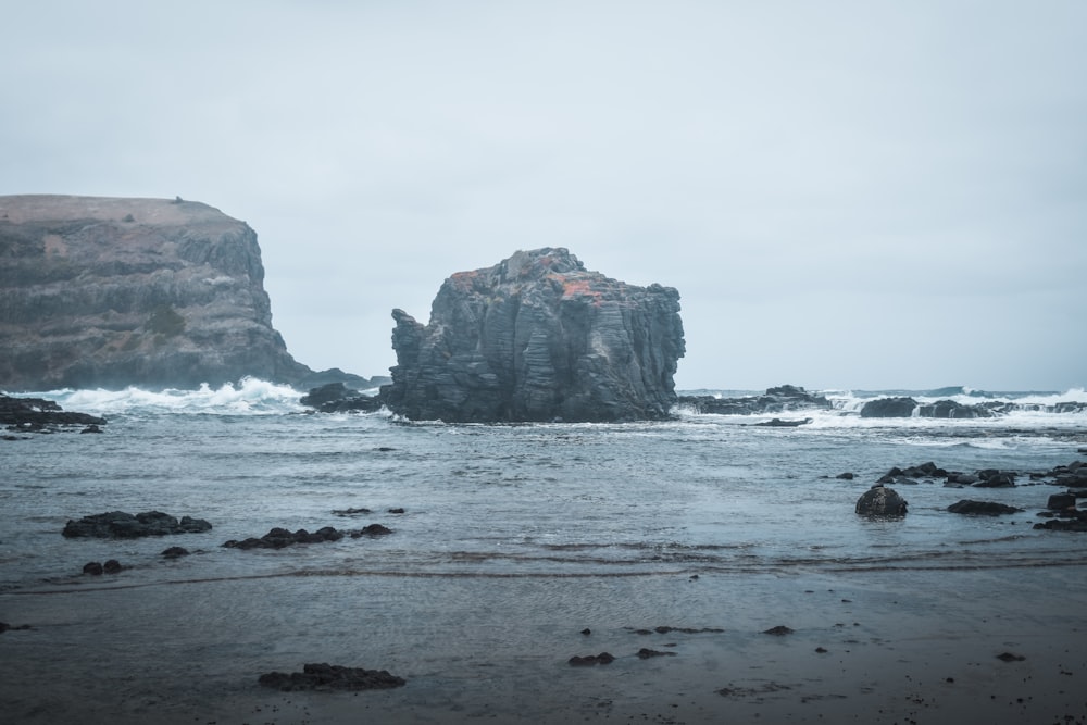 a large rock formation in the middle of a body of water