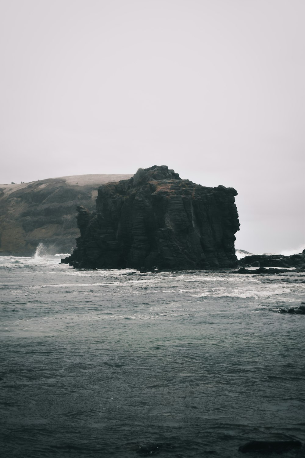 a rock outcropping in the middle of a body of water