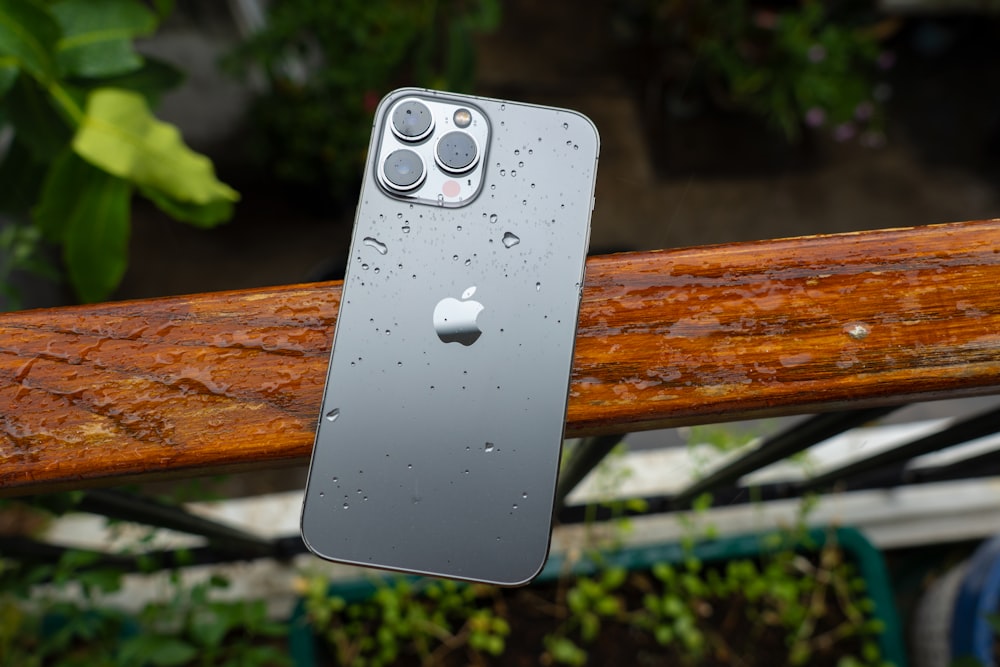 a close up of an iphone on a wooden rail