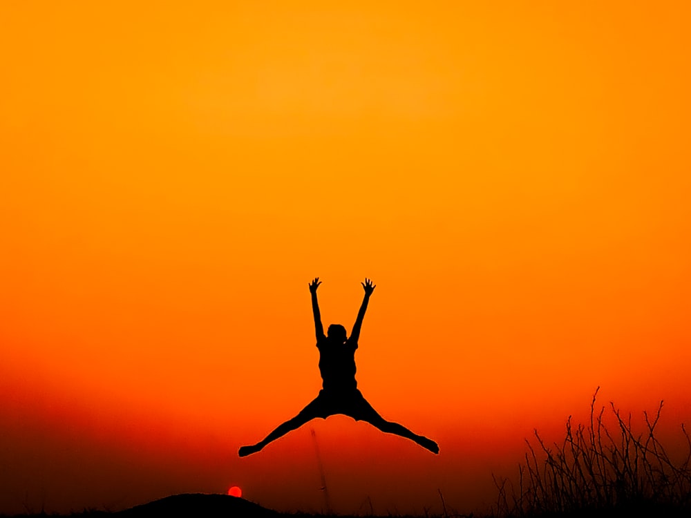 a person jumping in the air at sunset