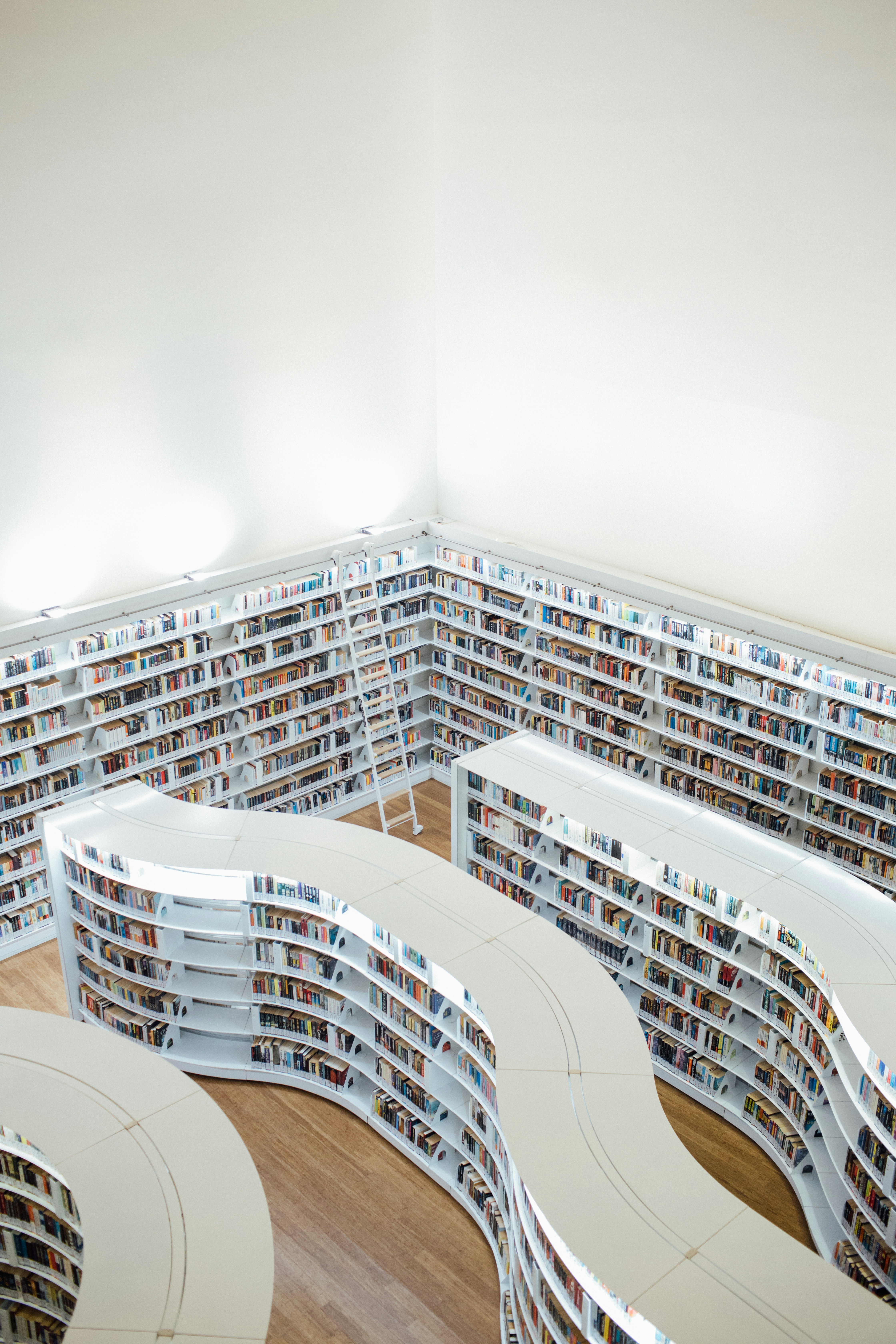 a room filled with lots of books on top of a hard wood floor