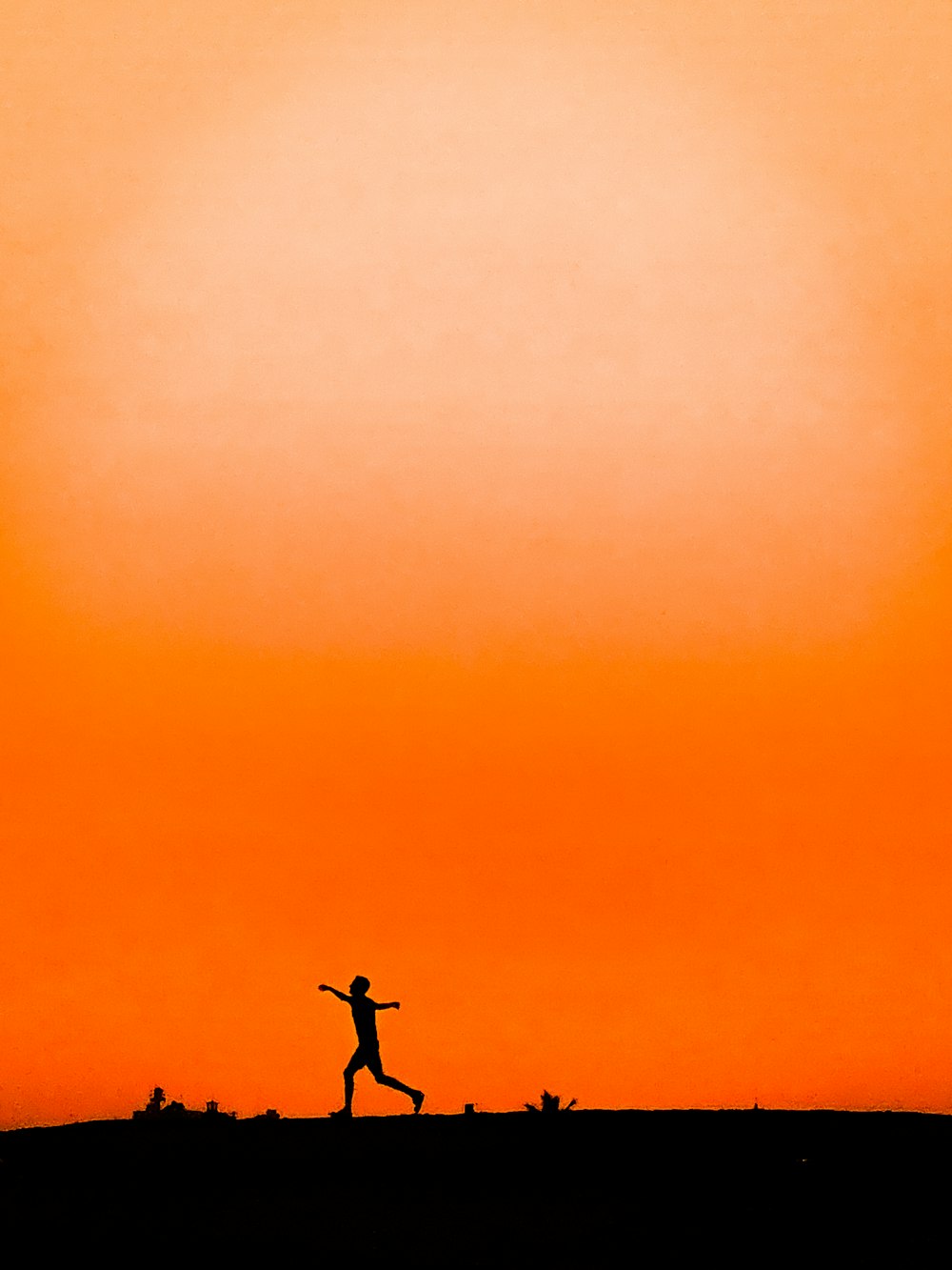a person running across a field at sunset