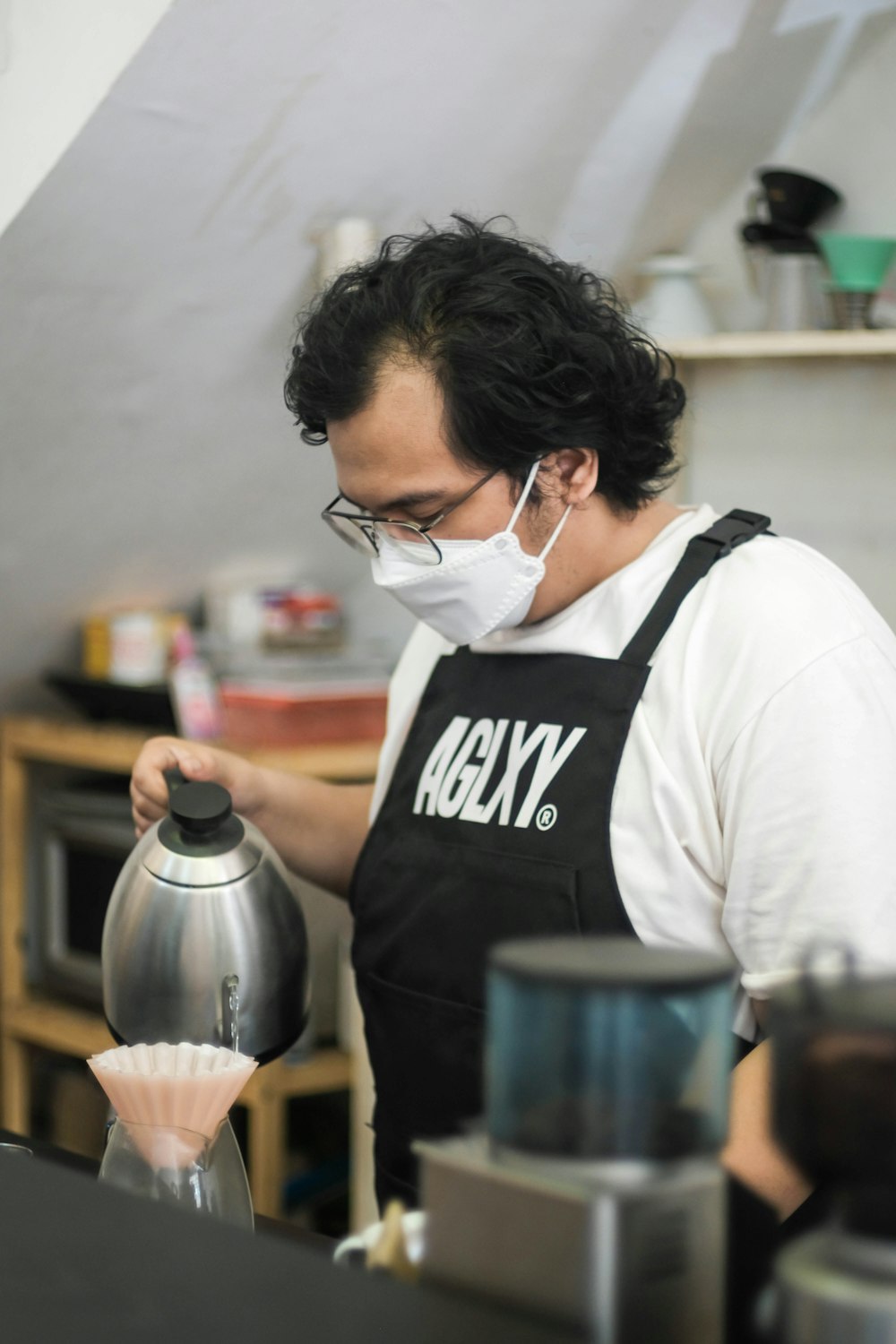 a man wearing a face mask while pouring something into a blender