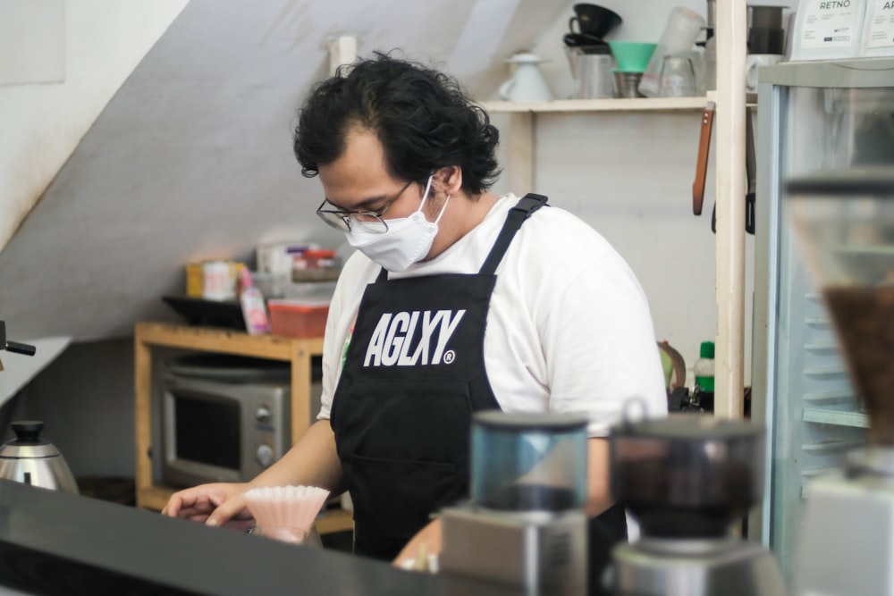 a man wearing a face mask in a kitchen