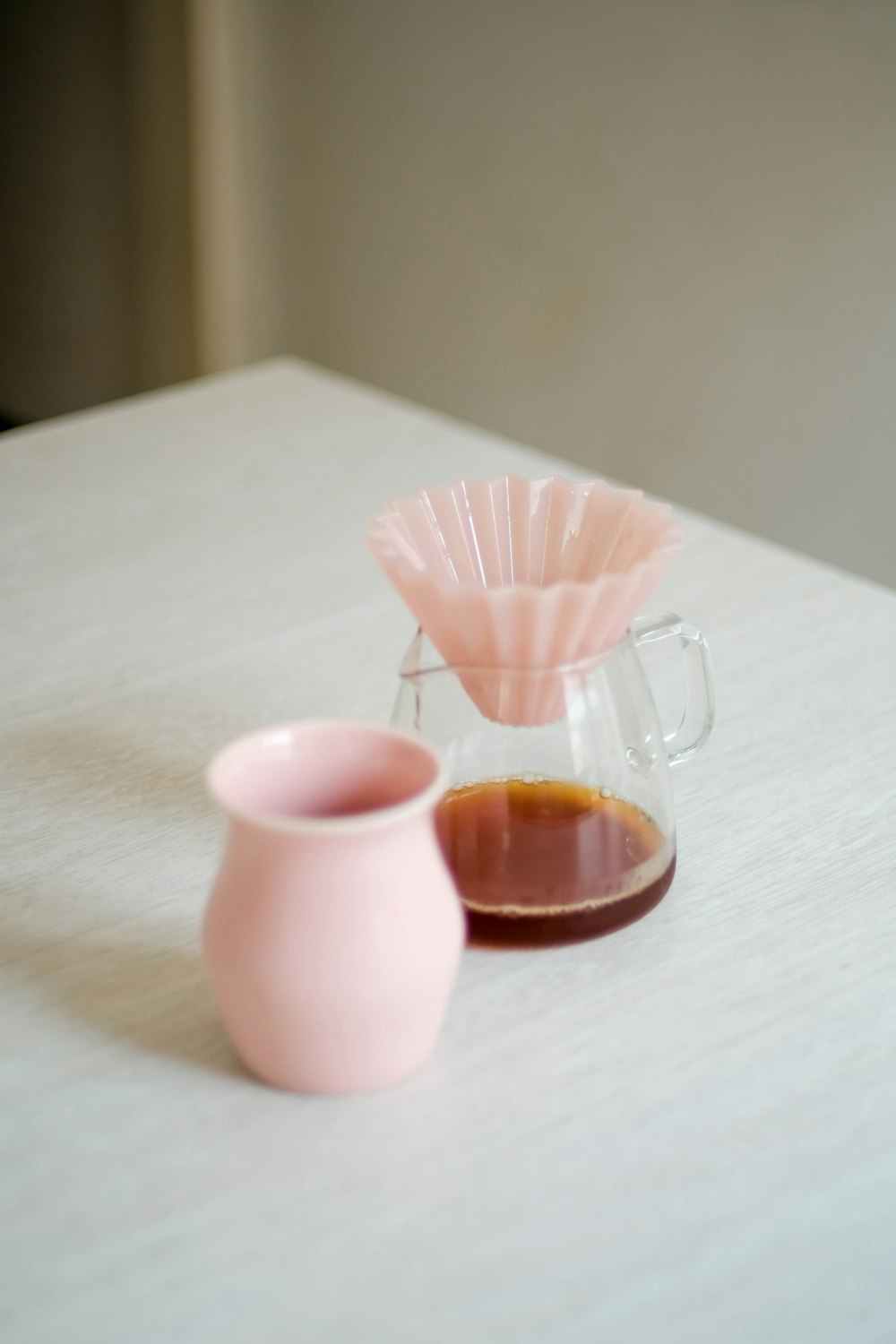 une table avec un vase et une tasse dessus