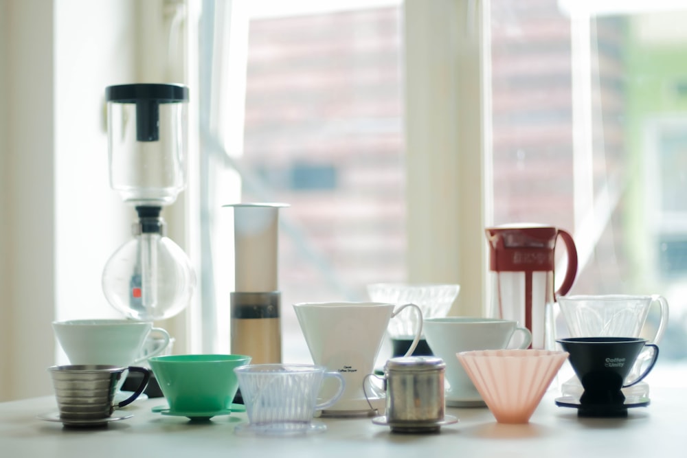 a table topped with lots of cups and a blender