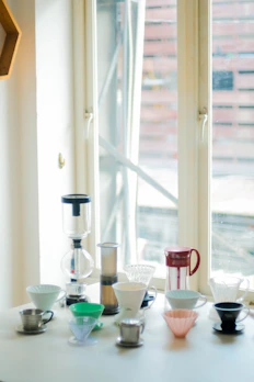 A variety of sleek coffee brewing tools arranged neatly on a wooden table.