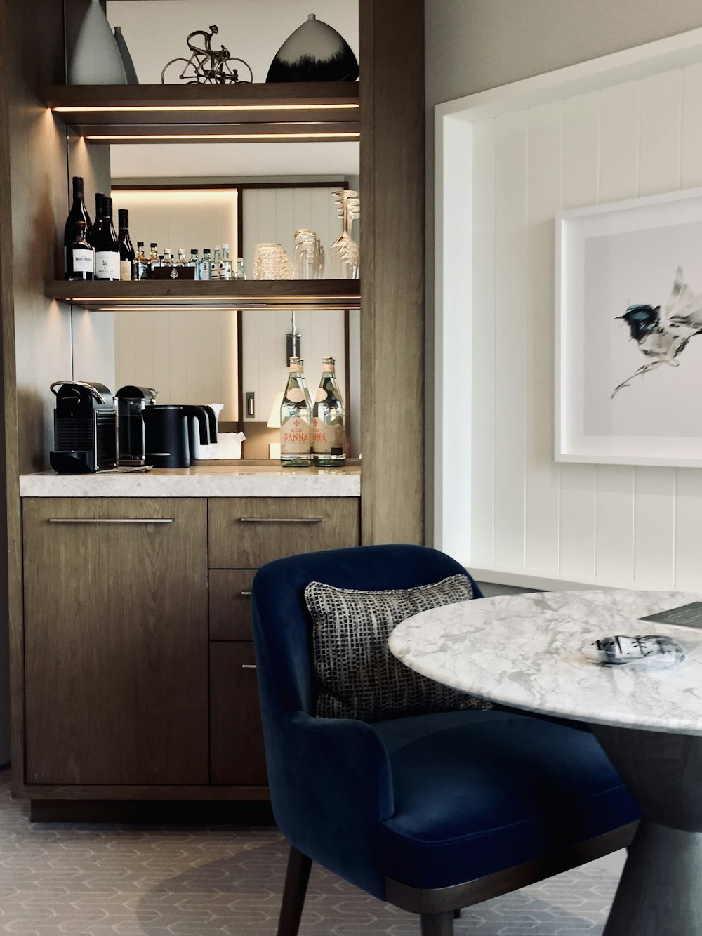 a kitchen with a marble table and blue chairs