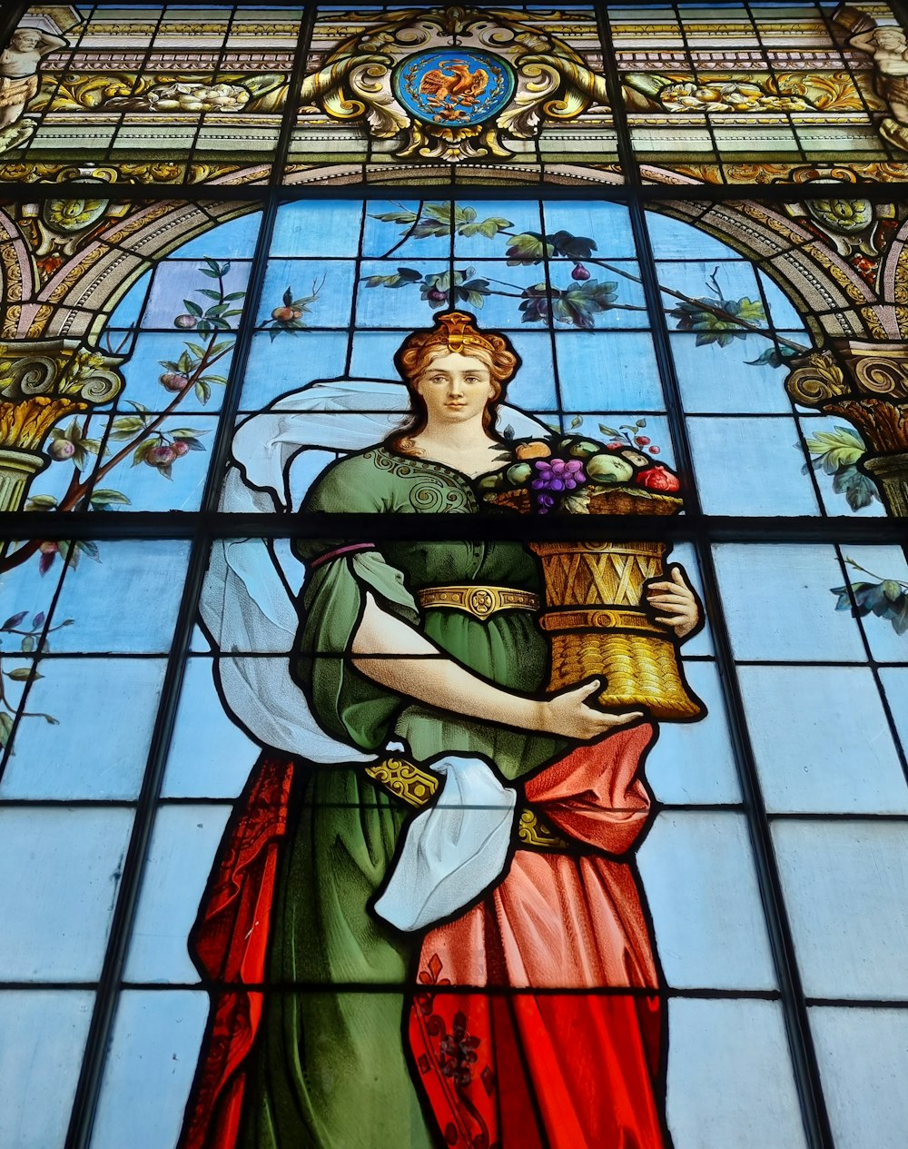 a stained glass window with a woman holding a basket