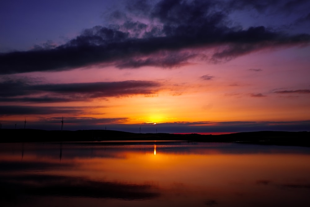 the sun is setting over a body of water